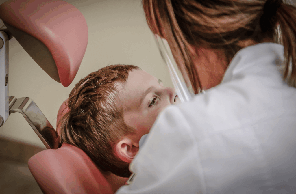 How Much Does a Dental Check-Up and Clean Cost? 1 Dentist examining a young patient at a check-up