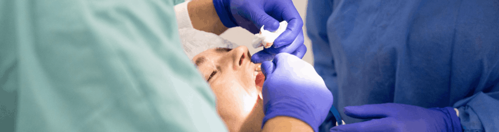 Pain After Tooth Extraction: What Is Normal and What Helps 1 Dental team treating a patient in the chair