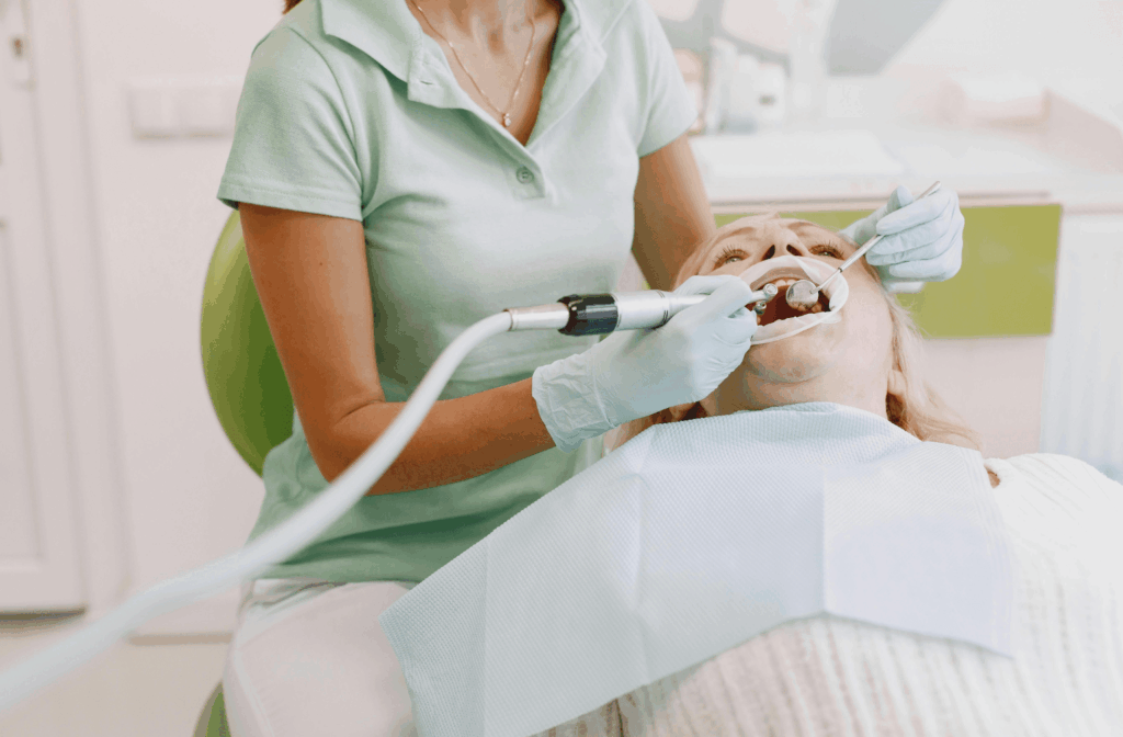 Deep Cleaning Teeth Cost in Australia: What to Expect 1 Dental practitioner cleaning a patient's teeth with a scaler
