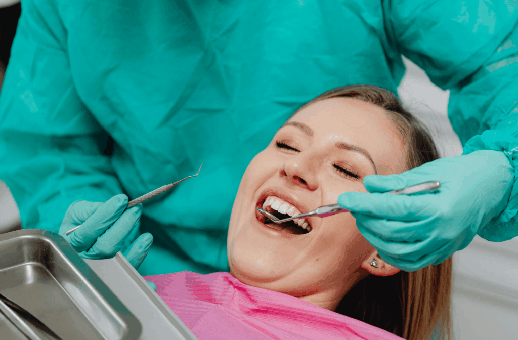 Bleeding Gums When Flossing: Causes and What to Do 1 Dentist checking a patient's gums during a dental examination