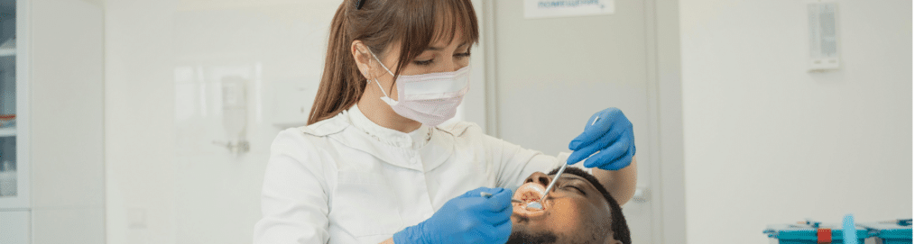 Sore Inside Cheek: Common Causes of Mouth Sores and Bumps 1 Dentist examining a sore inside the cheek during a check-up